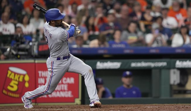 Texas Rangers&#x27; Marcus Semien hits a grand slam against the Houston Astros during the seventh inning of a baseball game Sunday, April 16, 2023, in Houston. (AP Photo/David J. Phillip)
