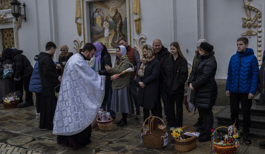 Orthodox Christian worshipers and their traditional Easter baskets are blessed during Easter Sunday at the Pechersk Lavra monastic complex Kyiv, Sunday, April 16, 2023. (AP Photo/Bernat Armangue)