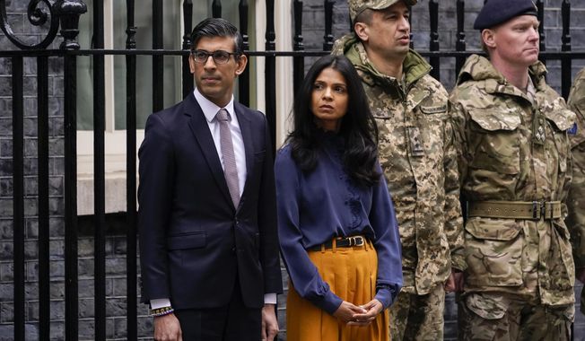 Britain&#x27;s Prime Minister Rishi Sunak and his wife Akshata Murthy joined outside 10 Downing Street by Ukrainian Ambassador to the UK, Vadym Prystaiko and his wife Inna (not pictured) and members of the Ukrainian Armed Forces and representatives from each Interflex nation, during a minute&#x27;s silence to mark the one-year anniversary of the full-scale Russian invasion of Ukraine, in London, on Feb. 24, 2023. Sunak is under investigation over allegations he failed to disclose shares his wife owns in a child care business that stands to benefit from his government&#x27;s budget, a parliamentary watchdog disclosed. (AP Photo/Alberto Pezzali, File)