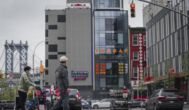 A six-story glass facade building, center, is believed to be the site of a foreign police outpost for China in New York&#x27;s Chinatown, Monday, April 17, 2023. Justice Department officials say two men have been arrested on charges that they helped establish a secret police outpost in New York City on behalf of the Chinese government. (AP Photo/Bebeto Matthews)