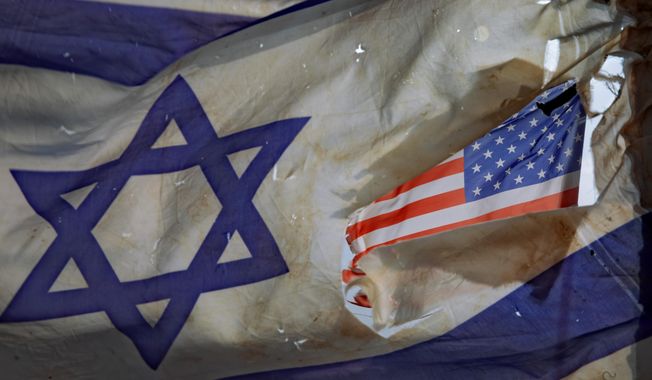 A U.S. flag is seen through a hole torn in an Israel national flag, as they wave in the wind at a horse ranch, near the southern Israeli town of Sderot, Friday, Nov. 20, 2020. Researchers say that antisemitism rose in the U.S. in 2022 and shows little sign of abating worldwide as political radicals have gained mainstream popularity. (AP Photo/Oded Balilty) **FILE**