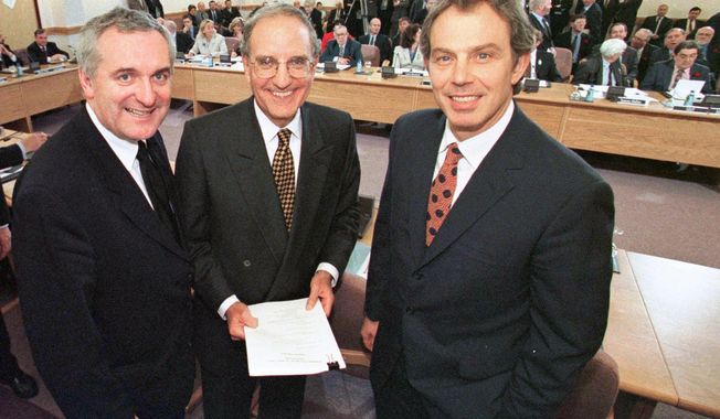 From left, Irish Prime Minister Bertie Ahern, U.S. Sen. George Mitchell, and British Prime Minister Tony Blair, pose together after signing the Good Friday Agreement, in, Belfast, Northern Ireland, Friday, April 10, 1998. Former U.S. President Bill Clinton and past leaders of the U.K. and Ireland are gathering in Belfast on Monday, April 17, 2023, 25 years after their charm, clout and determination helped Northern Ireland strike a historic peace accord. (Dan Chung/Pool Photo via AP, File)