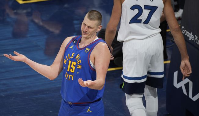 Denver Nuggets center Nikola Jokic, front, reacts after he was called for fouling Minnesota Timberwolves center Rudy Gobert in the first half of Game 1 of an NBA basketball first-round playoff series Sunday, April 16, 2023, in Denver. (AP Photo/David Zalubowski)