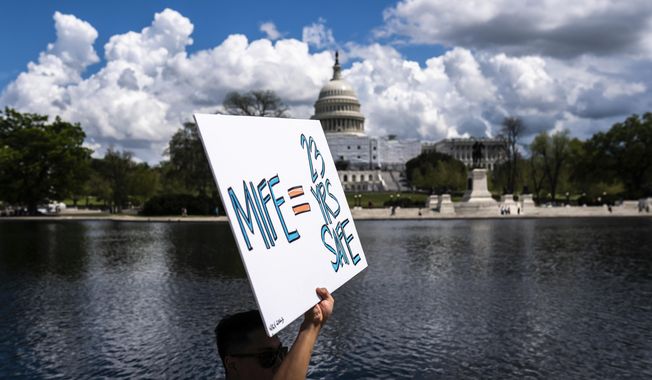 With the U.S. Capitol in the background, a protester holds a sign in support of mifepristone as they march past the capitol following a Planned Parenthood rally in support of abortion access outside the Supreme Court on Saturday, April. 15, 2023, in Washington. (AP Photo/Nathan Howard) **FILE**
