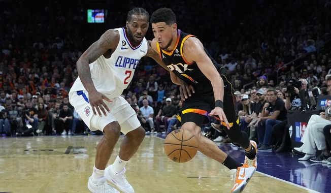 Phoenix Suns guard Devin Booker (1) drives on Los Angeles Clippers forward Kawhi Leonard (2) during the second half of Game 2 of a first-round NBA basketball playoff series, Tuesday, April 18, 2023, in Phoenix. (AP Photo/Matt York)