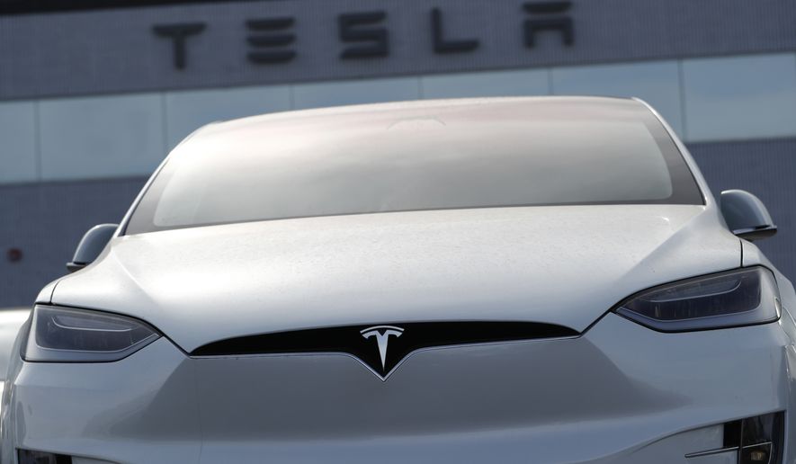 FILE-In this April 15, 2018, file photo, an unsold 2018 Model X 100d sits on a Tesla dealer&#x27;s lot in the south Denver suburb of Littleton, Colo.  Tesla reports earnings on Wednesday, April 19, 2023.  (AP Photo/David Zalubowski, File)