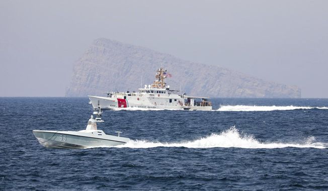 A U.S. Navy L3 Harris Arabian Fox MAST-13 drone boat and the U.S. Coast Guard cutter USCGC John Scheuerman transit the Strait of Hormuz on Wednesday, April 19, 2023. The U.S. Navy sailed its first drone boat through the strategic Strait of Hormuz on Wednesday, a crucial waterway for global energy supplies where American sailors often faces tense encounters with Iranian forces. (Information Systems Technician 1st Class Vincent Aguirre/U.S. Coast Guard via AP)