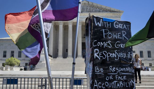 A demonstrator in favor of access to abortion pills places signage about the Supreme Court, Friday, April 21, 2023, outside the Supreme Court in Washington. (AP Photo/Jacquelyn Martin) **FILE**