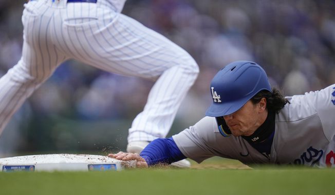 Los Angeles Dodgers&#x27; James Outman dives safely back to first base beating the pick-off throw to Chicago Cubs first baseman Eric Hosmer during the fourth inning of a baseball game Saturday, April 22, 2023, in Chicago. (AP Photo/Erin Hooley)