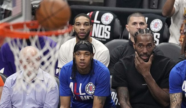 Los Angeles Clippers forward Kawhi Leonard, right, watches from the bench during the first half in Game 4 of a first-round NBA basketball playoff series against the Phoenix Suns Saturday, April 22, 2023, in Los Angeles. (AP Photo/Mark J. Terrill) **FILE**