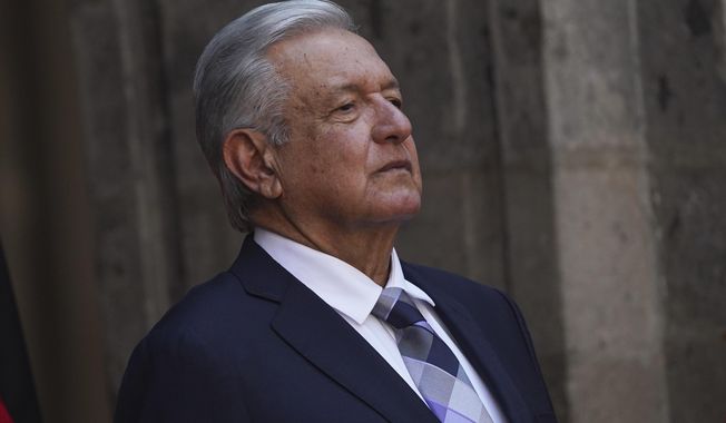 Mexican President Andres Lopez Obrador stands at the National Palace during a ceremony in Mexico City, Sept. 20, 2022. Lopez Obrador suspended a tour of the Yucatan peninsula Sunday, April 23, 2023, after acknowledging he tested positive for the coronavirus, having previously suffered two bouts of COVID-19. (AP Photo/Marco Ugarte, File)