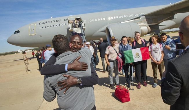 In this photo provided by the Spanish Defence Ministry passengers from Sudan disembark from a Spanish Air Force aircraft at Torrejon Air Base in Madrid, Monday April. 24, 2023. (Spanish Defence Ministry via AP)