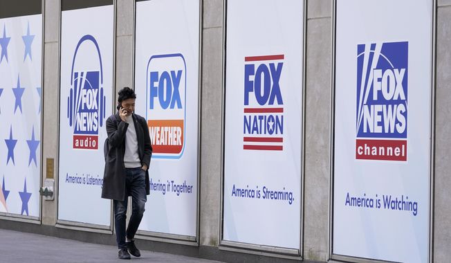 A man walks past the News Corp. and Fox News headquarters on April 19, 2023, in New York. Fox News agreed Wednesday, April 26, to hand over reams of documents produced during the just-settled defamation lawsuit between Dominion Voting Machines to another voting technology firm, Smartmatic, which in a $2.7 billion suit accuses the cable news giant of damaging its reputation because of the network’s promotion of lies about the 2020 election. (AP Photo/Mary Altaffer, File)