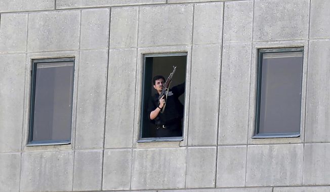 An armed man stands in a window of the parliament building during an attack by militants in Tehran, Iran on June 7, 2017. An Iranian court issued a $312.9 million judgment against the United States over a 2017 Islamic State-claimed attack on Tehran, authorities said Wednesday, April 26, 2023, the latest judicial action between the nations amid their decadeslong enmity. (Omid Vahabzadeh/Fars News Agency via AP, File)