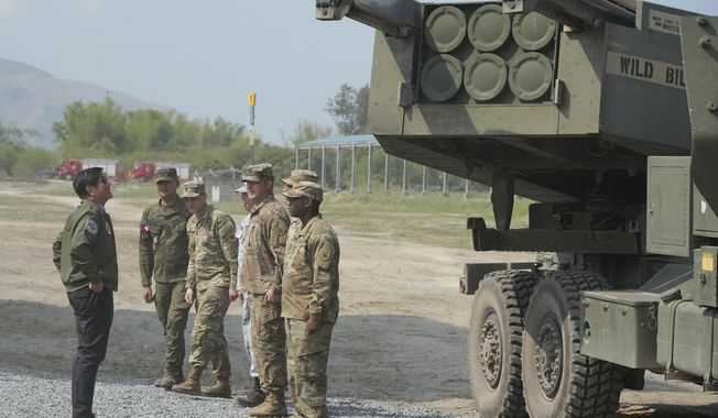 Philippine President Ferdinand Marcos Jr., left, looks at a U.S. M142 High Mobility Artillery Rocket System (HIMARS) during a Combined Joint Littoral Live Fire Exercise at the joint military exercise called &quot;Balikatan,&quot; Tagalog for shoulder-to-shoulder in a Naval station in Zambales province, northern Philippines on Wednesday, April 26, 2023. The long-time treaty allies are holding their largest joint military exercises that are part of a show of American firepower that has alarmed China. (AP Photo/Aaron Favila)