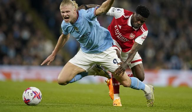 Arsenal&#x27;s Thomas Partey, right, fights for the ball with Manchester City&#x27;s Erling Haaland during the English Premier League soccer match between Manchester City and Arsenal at Etihad stadium in Manchester, England, Wednesday, April 26, 2023. (AP Photo/Dave Thompson)