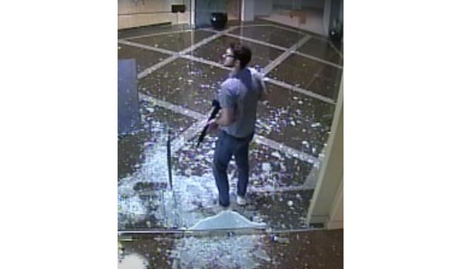 This image taken from surveillance video provided by the Louisville Metro Police Department shows bank employee Connor Sturgeon, 25, carrying an AR-15 assault-style rifle after opening fire at Old National Bank, in Louisville, Ky., Monday, April 10, 2023. Sturgeon, a man who opened fire at a Louisville bank, killing five co-workers, had confronted mental health problems over the last year and the situation appeared to be managed until just days before the shooting, his mother said. (Courtesy of Louisville Metro Police Department via AP, File)