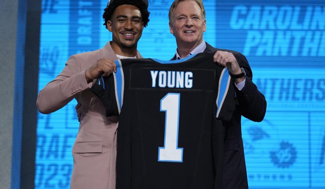Alabama quarterback Bryce Young gets a jersey from NFL Commissioner Roger Goodell after being chosen by Carolina Panthers with the first overall pick during the first round of the NFL football draft, Thursday, April 27, 2023, in Kansas City, Mo. (AP Photo/Jeff Roberson)