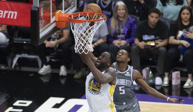 Golden State Warriors forward Draymond Green (23) is fouled by Sacramento Kings guard De&#x27;Aaron Fox (5) as he scores a basket during the first half of Game 5 of an NBA basketball first-round playoff series Wednesday, April 26, 2023, in Sacramento, Calif. (AP Photo/José Luis Villegas)