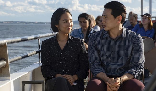 This image released by A24 shows Greta Lee, left, and Teo Yoo in a scene from &quot;Past Lives.&quot; (Jon Pack/A24 via AP)