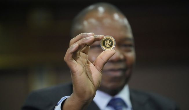 Reserve Bank of Zimbabwe Governor, John Mangudya holds a sample of a gold coin at the launch in Harare, on July 25, 2022. Zimbabwe will launch a digital currency next month by introducing “tokens” that are backed by gold reserves and can be transferred between people and businesses as a form of payment, the country&#x27;s central bank said Friday April 28, 2023. (AP Photo/Tsvangirayi Mukwazhi) **FILE**
