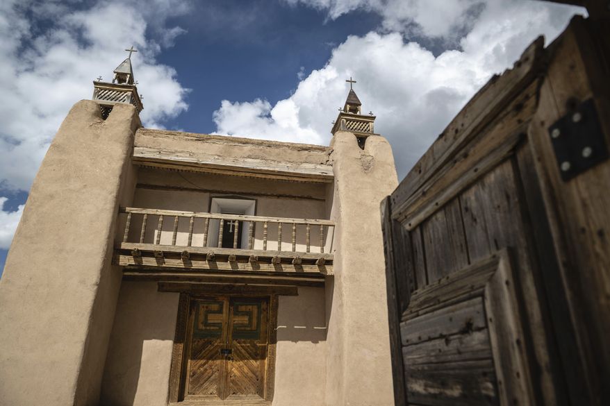 An exterior view of the San Jose de Gracia Catholic Church, built in 1760, in Las Trampas, New Mexico, Friday, April 14, 2023. Threatened by depopulation, dwindling congregations and fading traditions, some of their descendants are fighting to save these historic adobe structures and the uniquely New Mexican way of life they represent. (AP Photo/Roberto E. Rosales)