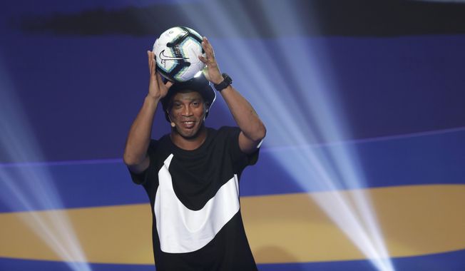 Brazil&#x27;s Ronaldinho Gaucho shows the official ball during the draw for the 2019 Copa America soccer tournament in Rio de Janeiro, Brazil, Thursday, Jan. 24, 2019. Brazil great Ronaldinho is launching a worldwide street soccer league to give talented young players an opportunity to showcase their skills and follow the same path to stardom as the former Barcelona player. (AP Photo/Andre Penner, File)