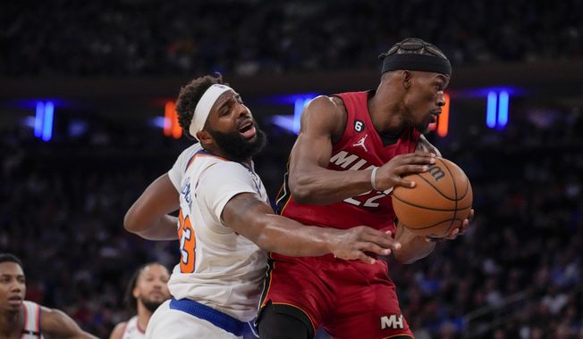 Miami Heat forward Jimmy Butler (22) rebounds against New York Knicks center Mitchell Robinson (23) during the first half of Game 1 in the NBA basketball Eastern Conference semifinals playoff series, Sunday, April 30, 2023, in New York. (AP Photo/John Minchillo)