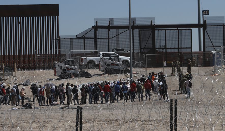 Migrants line up after being detained by US authorities at the US-Mexico border in Ciudad Juárez, Mexico, Sunday, April 30, 2023. (AP Photo/Christian Chávez)