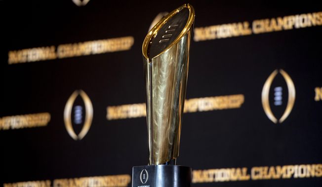 FILE - The championship trophy stands on a table during a news conference ahead of the national championship NCAA College Football Playoff game between Georgia and TCU, Sunday, Jan. 8, 2023, in Los Angeles. The first-round games of the inaugural 12-team College Football Playoff will be played on Friday night and Saturday of the third week of December 2024, and the semifinals will be played in early January on weeknights to avoid conflicting with the NFL playoffs, CFP executive director Bill Hancock confirmed on Thursday, April 27, 2023. (AP Photo/Mike Stewart, File)