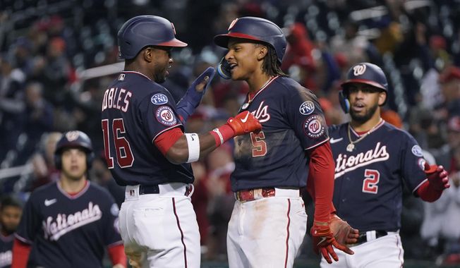 Washington Nationals&#x27; CJ Abrams (5) and Victor Robles (16) celebrate after both scored on an RBI-double by Alex Call during the seventh inning of a baseball game against the Chicago Cubs in Washington, Tuesday, May 2, 2023. (AP Photo/Manuel Balce Ceneta)
