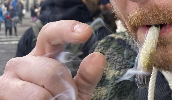 A person smokes marijuana in lower Manhattan outside the first legal dispensary for recreational marijuana in New York on Thursday, Dec. 29, 2022. (AP Photo/Ted Shaffrey) **FILE**