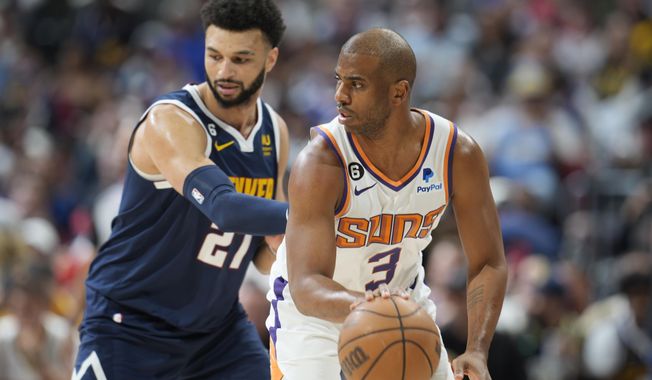 Phoenix Suns guard Chris Paul, right, looks to pass the ball as Denver Nuggets guard Jamal Murray, left, defends in the first half of Game 2 of an NBA second-round playoff series Monday, May 1, 2023, in Denver. (AP Photo/David Zalubowski)