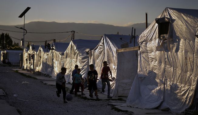 Syrian children play soccer by their tents at a refugee camp in the town of Bar Elias in the Bekaa Valley, Lebanon, July 7, 2022. Against the backdrop of a worsening economic crisis and political stalemate, Lebanese officials have launched a crackdown on the country&#x27;s Syrian refugees. (AP Photo/Bilal Hussein, File)