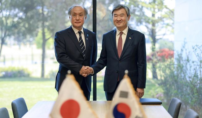 In this photo provided by South Korea Presidential Office, Takeo Akiba, left, Japan&#x27;s National Security Adviser shakes hands with Cho Tae-yong, South Korean National Security Adviser, right, in Seoul, South Korea, Wednesday, May 3, 2023. (South Korea Presidential Office via AP)