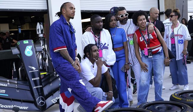 Mercedes driver Lewis Hamilton, left, of Britain, poses for a photo with A$AP Rocky, second from left, in the pit lane ahead of the Formula One Miami Grand Prix auto race at Miami International Autodrome, Thursday, May 4, 2023, in Miami Gardens, Fla. (AP Photo/Lynne Sladky)