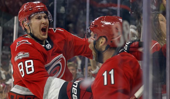 Carolina Hurricanes&#x27; Jordan Staal (11) celebrates with teammate Martin Necas (88) after scoring during the second period of Game 2 of an NHL hockey Stanley Cup second-round playoff series against the New Jersey Devils in Raleigh, N.C., Friday, May 5, 2023. (AP Photo/Karl B DeBlaker)