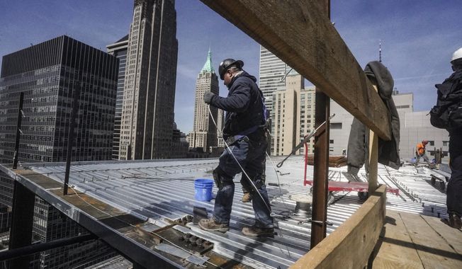 Construction workers install roofing on a high rise in Manhattan&#x27;s financial district on Tuesday, April 11, 2023, in New York. On Friday, the U.S. government issues the April jobs report. (AP Photo/Bebeto Matthews, File)