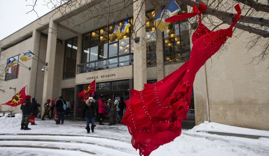 A red dress hangs on a tree in the courtyard at Winnipeg City Hall during a rally, Thursday, Dec. 15, 2022, in Winnipeg, Manitoba, to call on the city to cease dumping operations at Brady landfill and conduct a search for the remains of missing and murdered indigenous women believed to be buried there. Friday, May 5, 2023, marks Missing and Murdered Indigenous Peoples Awareness Day, a solemn day meant to draw more attention to the disproportionate number of Indigenous people who have vanished or have faced violence. (Daniel Crump/The Canadian Press via AP, File)