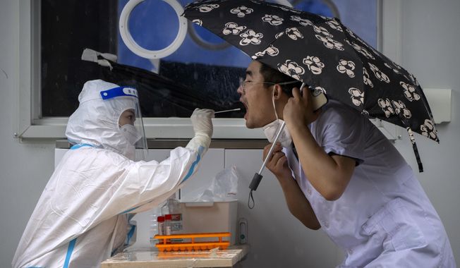 A worker wearing a protective suit swabs a man&#x27;s throat for a COVID-19 test at a coronavirus testing site in Beijing, on June 22, 2022. The World Health Organization said Friday, May 5, 2023, that COVID-19 no longer qualifies as a global emergency, marking a symbolic end to the devastating coronavirus pandemic that triggered once-unthinkable lockdowns, upended economies and killed millions of people worldwide. (AP Photo/Mark Schiefelbein) **FILE**