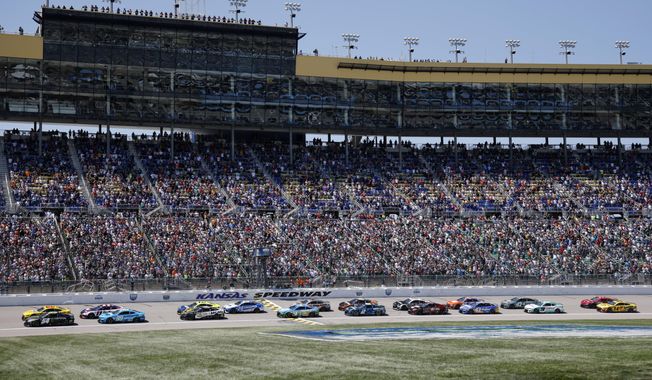 Drivers head down the front straightaway at the start of a NASCAR Cup Series auto race at Kansas Speedway in Kansas City, Kan., Sunday, May 7, 2023. (AP Photo/Colin E. Braley)