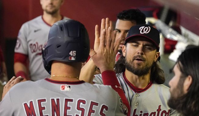 Washington Nationals&#x27; Joey Meneses, left, gets a high-five from his pitcher Trevor Williams after scoring their first run against the Arizona Diamondbacks in the second inning during a baseball game, Sunday, May 7, 2023, in Phoenix. (AP Photo/Darryl Webb)