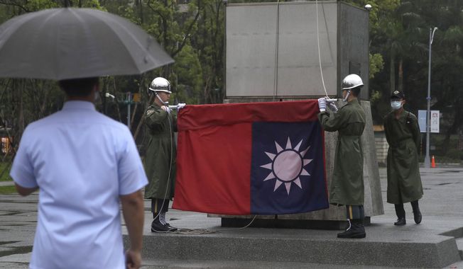 Taiwanese soldiers fold the national flag during the daily flag ceremony at the National Dr. Sun Yat-Sen Memorial Hall in Taipei, Taiwan, Sunday, May 7, 2023. (AP Photo/Chiang Ying-ying) **FILE**