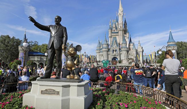 A statue of Walt Disney and Micky Mouse stands in front of the Cinderella Castle at the Magic Kingdom at Walt Disney World in Lake Buena Vista, Fla., Jan. 9, 2019. It’s going on six months since Bob Iger returned to The Walt Disney Co., and while there’s been plenty of issues to keep him busy, one has definitely been top of mind: reconnecting with the Disney theme park die-hards and restoring their faith in the brand. (AP Photo/John Raoux, File)