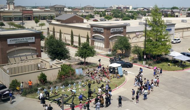 People gather around a makeshift memorial just outside of a mall where several people were killed in a mass shooting, Monday, May 8, 2023, in Allen, Texas. (AP Photo/Tony Gutierrez) ** FILE **