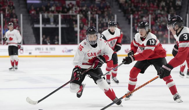 Canada&#x27;s Connor Bedard, left, skates past Austria&#x27;s Lukas Horl, right, and Luca Auer during the second period of a world junior hockey championships game Thursday, Dec. 29, 2022, in Halifax, Nova Scotia. The NHL draft lottery is drawn, determining which team gets the chance to select Connor Bedard with the No. 1 pick. The Anaheim Ducks, Columbus Blue Jackets and Chicago Blackhawks have the highest odds of landing the most anticipated top pick since Connor McDavid in 2015. (Darren Calabrese/The Canadian Press via AP, File)