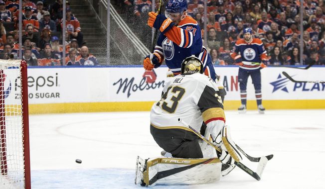 Vegas Golden Knights goalie Adin Hill (33) makes a save against Edmonton Oilers&#x27; Klim Kostin (21) during second-period NHL hockey Stanley Cup second-round playoff game action in Edmonton, Alberta, Monday, May 8, 2023. (Jason Franson/The Canadian Press via AP)