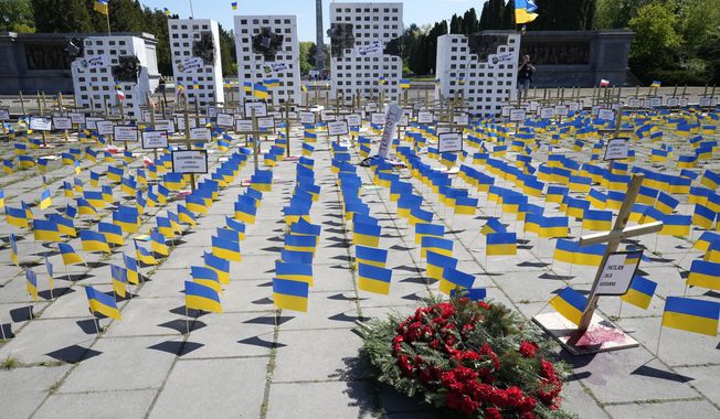 A wreath placed by Russia&#x27;s ambassador to Poland lies in front of an installation representing Russian crimes in Ukraine, in Warsaw, Poland, on Tuesday May 9, 2023. The one-day installation was set up by Ukrainian activists on the day when Russia celebrates the Allied defeat of Nazi Germany at the end of World War II. The large installation blocked the path of Russia&#x27;s ambassador to Poland and prevented him from placing the wreath at a Warsaw memorial to Soviet soldiers. (AP Photo/Czarek Sokolowski)