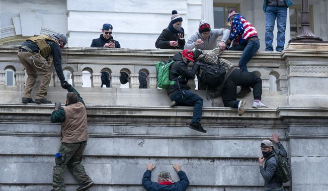 Rioters loyal to President Donald Trump climb the west wall of the U.S. Capitol, Jan. 6, 2021, in Washington. (AP Photo/Jose Luis Magana, File)