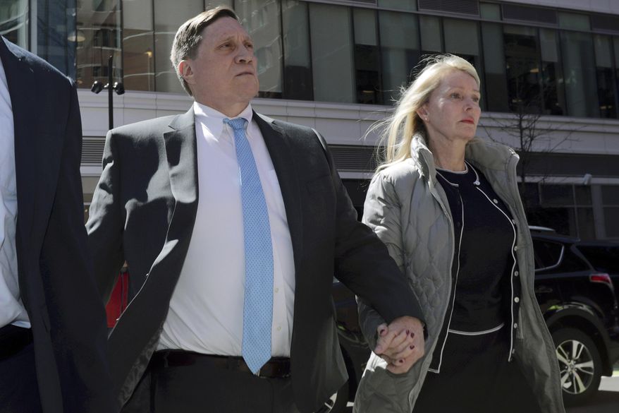 John Wilson arrives at federal court with his wife Leslie, April 3, 2019, to face charges in a nationwide college admissions bribery scandal, in Boston. The 1st U.S. Circuit Court of Appeals on Wednesday, May 10, 2023, overturned the convictions of two parents who were found guilty of paying bribes in the college admissions scandal. The appeals court upheld a tax count against John Wilson but tossed his other convictions. (AP Photo/Charles Krupa, File)